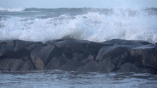 Waves rolling on the beach is a stormy day, winter mediterranean sea. Focene, Lazio, Italy. Slow motion