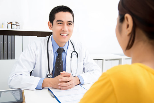 Handsome Asian doctor sharing information with patient