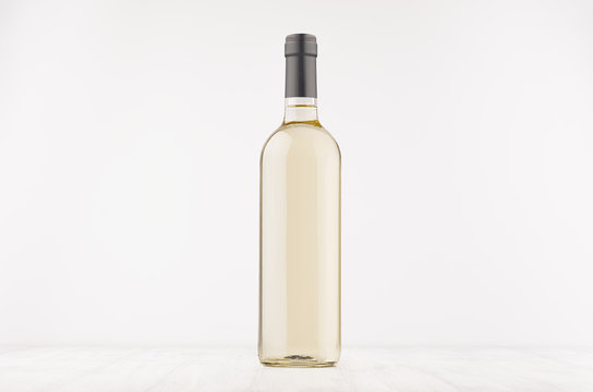 Fototapeta Transparent wine bottle with white wine on white wooden board, mock up. Template for advertising, design, branding identity.