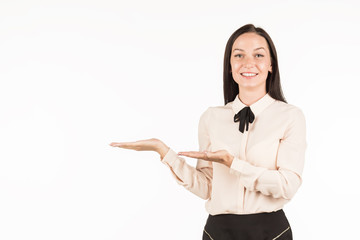 Young beautiful woman points to the object on the left / right. The girl smiles and points to the side. An attractive business lady is advertising something. 