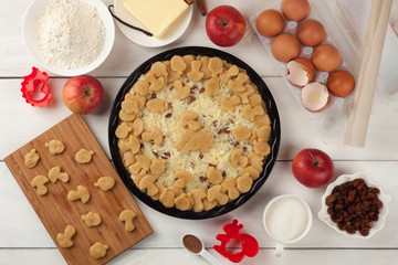 Apple pie tart, ingredients - apples, eggs, butter and cinnamon on rustic wooden background - top view