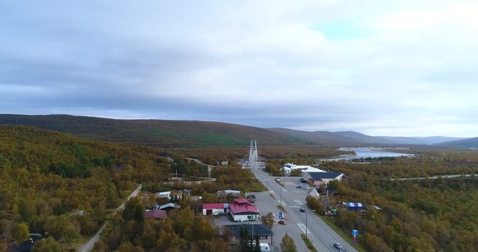 Arctic town, Cinema 4k aerial sideway view of utsjoki town and border bridge between norway and utsjoki town, on a cloudy autumn day, in utsjoki, Lapland, Lappi, Finland