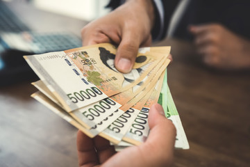 Client receiving money, South Korean Won currency,  from a businessman