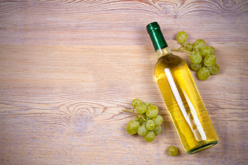 Bottle of wine on rustic wooden background, copy space, top view, horizontal. White wine