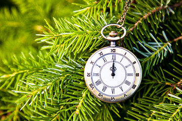 Christmas tree background. Happy New Year Xmas theme. Retro classic Vintage pocket watch over fir branches. Winter is coming. Time is running up, Clock Concept. Change of seasons.