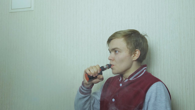 Young man smoking electronic cigarette. Young Man Using Vapourizer As Smoking Alternative