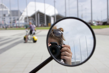 Motorcycle Mirror. The girl is making a person in the mirror of a motorcycle