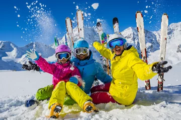 Foto op Plexiglas anti-reflex Wintersport Happy family enjoying winter vacations in mountains. Playing with snow, Sun in high mountains. Winter holidays.