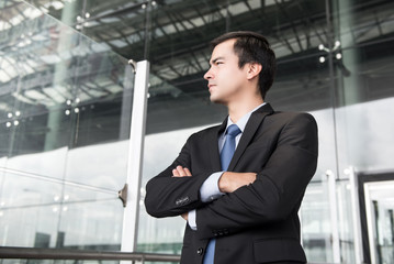 Fototapeta premium Businessman in dark gray suit crossing his arms