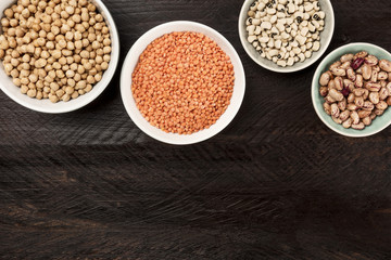 Legumes on dark background, from above with copy space