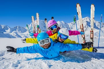 Foto auf Acrylglas Wintersport Happy family enjoying winter vacations in mountains. Playing with snow, Sun in high mountains. Winter holidays.  © Gorilla