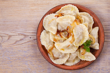 Dumplings, filled with meat and served with salty caramelized onion. Varenyky, vareniki, pierogi, pyrohy. Dumplings with filling. View from above, top studio shot, horizontal