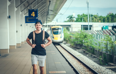 Young traveler walking with backpack on train staition and waiting train