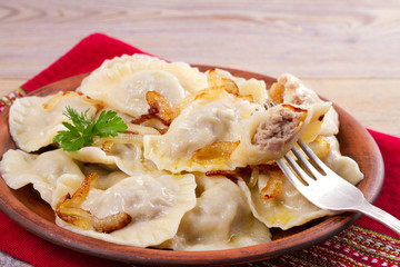 Dumplings, filled with meat and served with salty caramelized onion. Varenyky, vareniki, pierogi, pyrohy. Dumplings with filling, horizontal