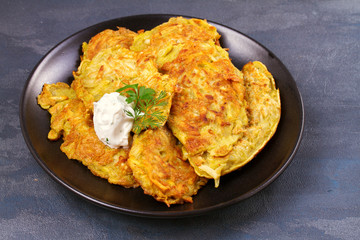 Potato Pancakes. Vegetable fritters. Latkes on black plate, horizontal