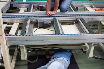 The technician repairing conveyor belt in factory