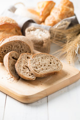 sliced baguette on wood block on white wood table