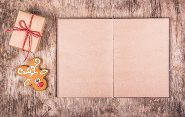 Open book with empty pages, gingerbread and a gift. New Year's and Christmas. Backgrounds and textures