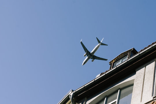 Airplane flying low above buildings, approach to landing