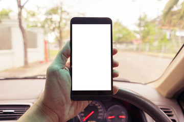 Hand holding mobile smart phone with blank space. Car parking scene vintage filter