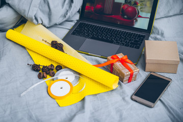 preparing christmas gift in bed near laptop
