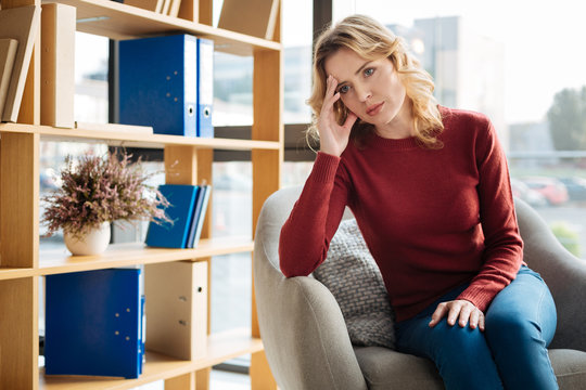 Stressful Situation. Sad Beautiful Young Woman Looking In Front Of Her And Holding Her Forehead While Being In A Stressful Situation