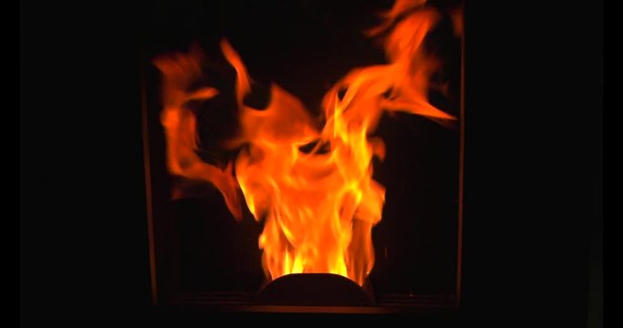 Flames and fire in the pellet stove warm the house in winter with ecology