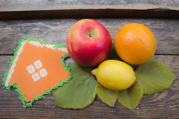 House and fruit on a wooden background