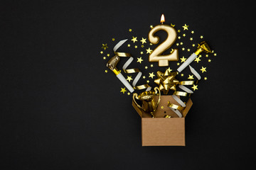 Number 2 gold celebration candle and gift box background