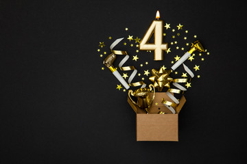 Fototapeta na wymiar Number 4 gold celebration candle and gift box background