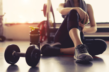 Frauenübungstraining in der Fitness-Studio-Fitnesspause entspannen sich mit Apfelfrucht nach dem Training von Sport mit Hantel und Protein-Shake-Flasche gesundes Lebensstil-Bodybuilding, Sportler-Builder-Muskel-Lifestyle.