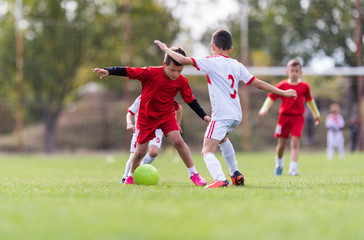 Fototapeta premium Young children players football match on soccer field
