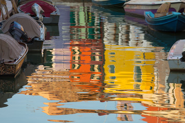 Fototapeta na wymiar brightly painted houses on the island of Burano, reflection in the water, Venice, Italy.