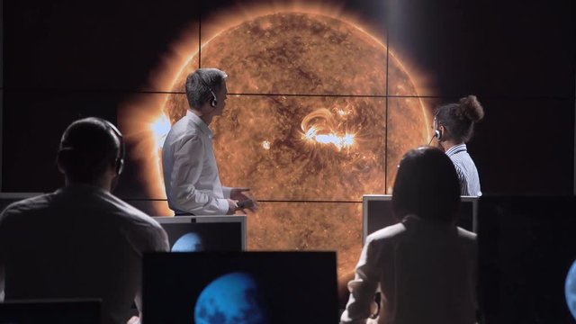 Multiracial team of scientists investigating and analyzing solar eclipse and solar activity. Elements of this image furnished by NASA.