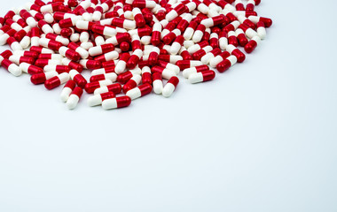 Red, white antibiotic capsules pills on white background with copy space. Drug resistance, antibiotic drug use with reasonable, health policy and health insurance concept.