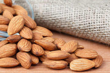 Almonds in bowl on wooden background