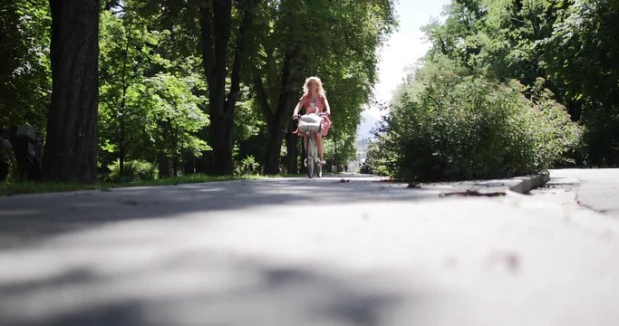 Young adult female cycling down street