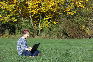 happy little girl playing laptop