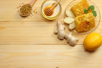 healthy background. honey, honeycomb, lemon, ginger on light wooden table. Top view with copy space