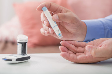 medicine, diabetes, glycemia, health care and people concept - close up of male finger with test stripe