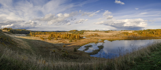 Autumn panorama of the Malsky valley and lake against the bright blue sky