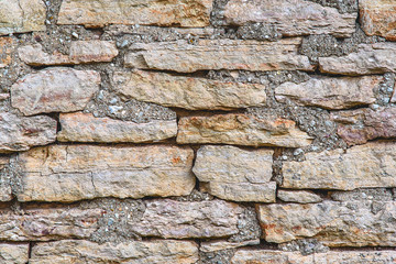 Horizontal shot of texture of a stone wall, old stones close-up