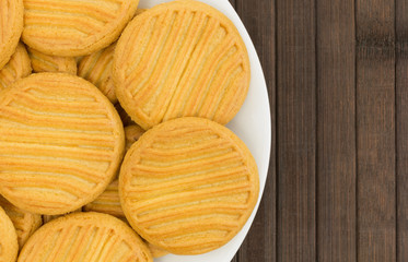 Top view of a plate full of sugar free shortbread cookies on a brown wood place mat.