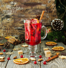 glass of hot mulled wine for the new year with ingredients for cooking, nuts and Christmas...