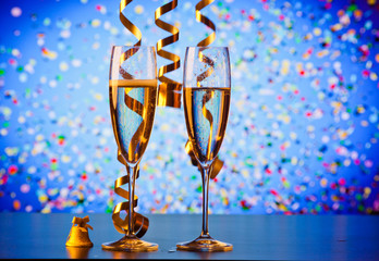 two champagne glasses with ribbons and falling confetti - New Year celebrations