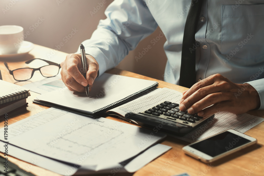 Poster businessman working on desk office with using a calculator to calculate the numbers, finance concept