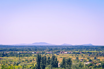 Beautiful summer landscape with city, mountains and dramatic cloudy sky