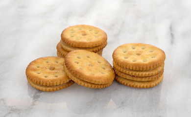 Several roasted peanut butter crackers on a gray marble table top.