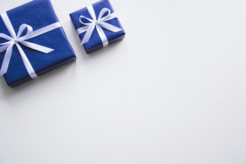 Fototapeta premium Background on a white desk decorated presents. Bright background symbolizes the new year celebration. Great useful template to wright words down. Red bow on a box. Beautiful packaging for present.