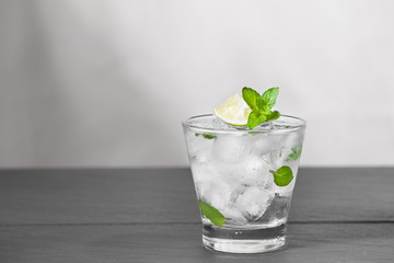 Mojito cocktail with lime and mint in glass on a grey stone background
